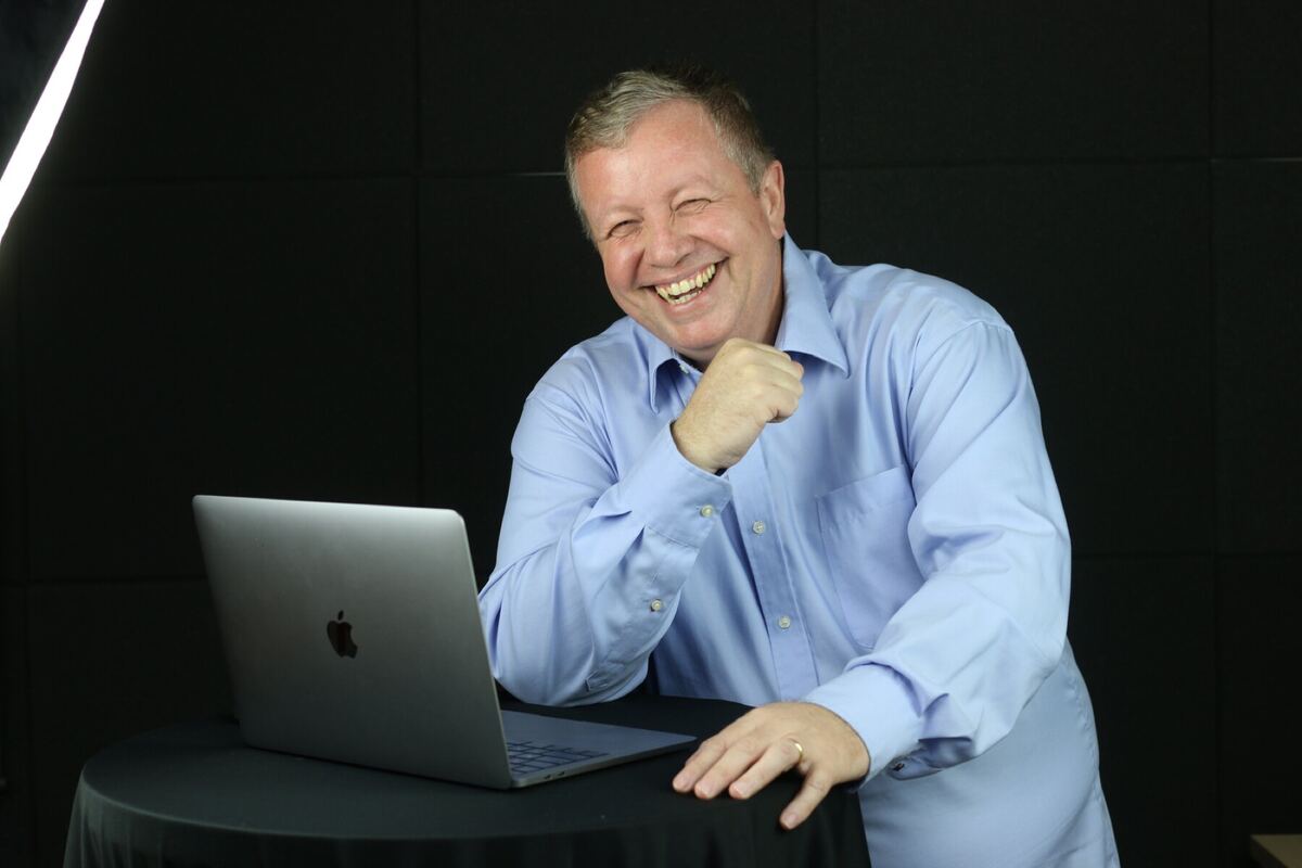 Michael Oliveira sorrindo, com o notebook aberto